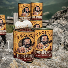 Bud Spencer Beans cans on a rocky surface with a mountainous background